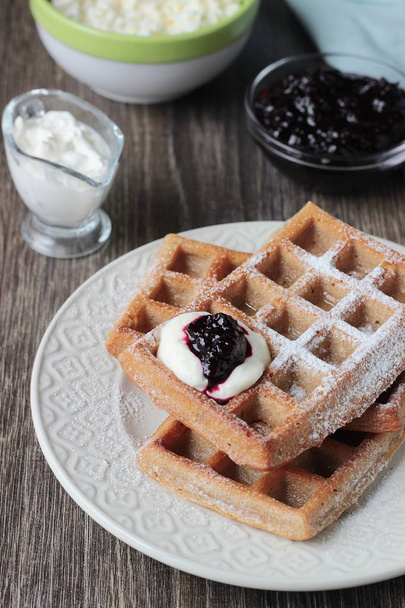 Traditional Belgian waffles with powdered sugar and cream on wooden table. Gourmet Breakfast.  - Foto, Imagem