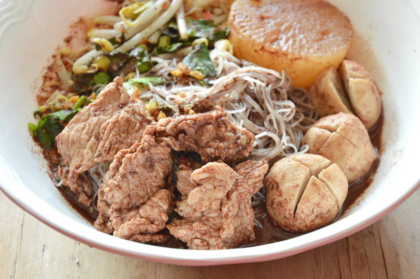 macarrão fino de arroz com bola de porco e carne em sopa marrom
 - Foto, Imagem
