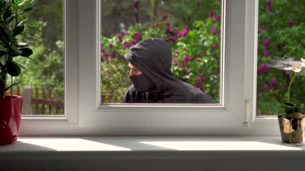 泥棒は窓から家に侵入します。 - 映像、動画