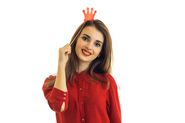 a beautiful young woman in a red shirt smiling at the camera with a paper Crown on head - Φωτογραφία, εικόνα