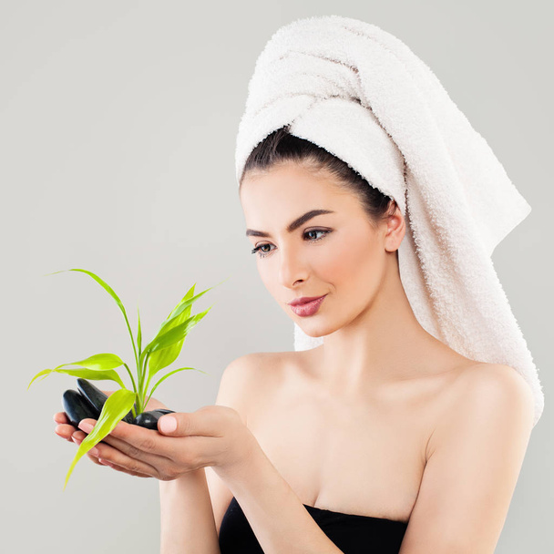 Spa Portrait of Healthy Woman with Black Stones and Green Bamboo - 写真・画像