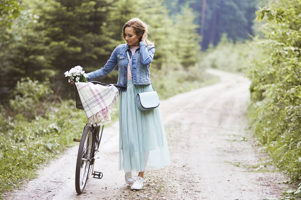 Nainen kävelee pyörän kanssa
  - Valokuva, kuva