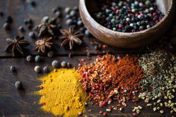pepper in bowl and spices with herbs on tabletop - Photo, Image