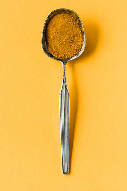 Cuchara de metal con polvo de curry
 - Foto, imagen