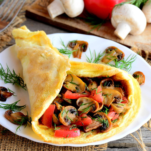 Houby omeleta s čerstvými rajčaty a kopr na bílé plotně a na dřevěný stůl. Rustikální styl. Closeup - Fotografie, Obrázek