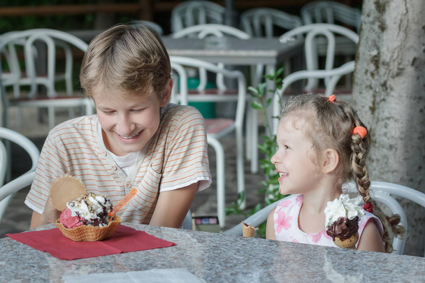 zwei Geschwister haben Spaß beim Essen ihres süßen italienischen Gelatineeis - Foto, Bild