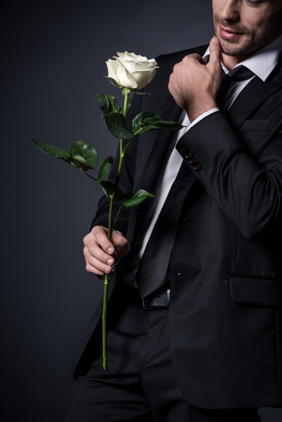 man in suit holding white rose - Фото, изображение