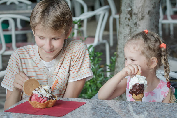 Boy and girl kids enjoying their Italian ice cream in gelateria - Photo, Image