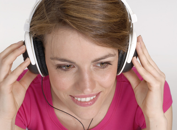 Young woman listening music and holding a headphones. - Φωτογραφία, εικόνα