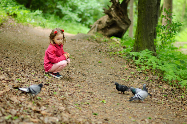 Girl feeds urban pigeons pigeons in the park. - Foto, Bild