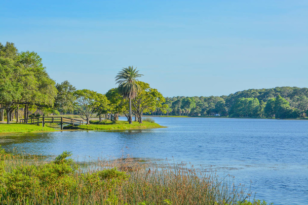 Un hermoso día para un paseo y la vista del puente de madera a la isla en John S. Taylor Park en Largo, Florida
. - Foto, Imagen