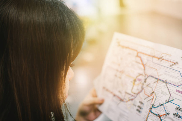 Közelkép kép gyönyörű nő keresi a tokyo vonat térképek: - Fotó, kép