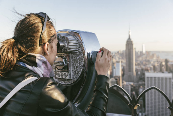 Tourist woman using binoculars in rooftop. - Fotoğraf, Görsel
