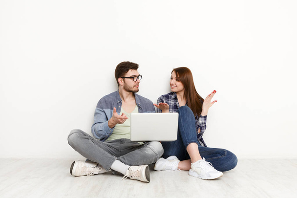 Paar kauft online ein, sitzt zu Hause auf dem Boden - Foto, Bild
