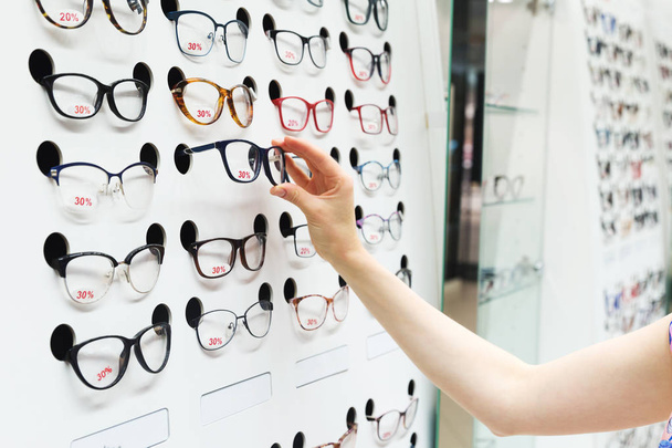 la elección de nuevas gafas ópticas en la tienda de óptica
 - Foto, Imagen