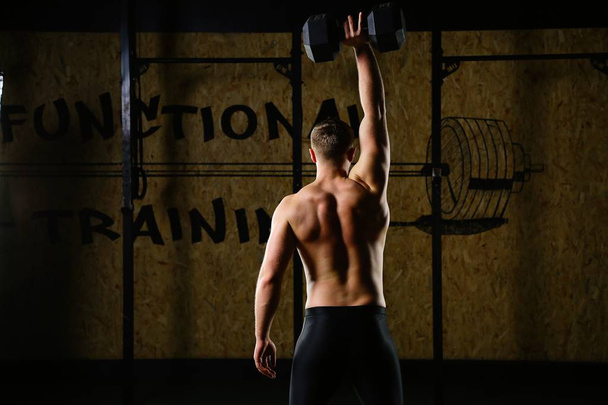 deportista haciendo ejercicio con mancuerna en el gimnasio
 - Foto, imagen