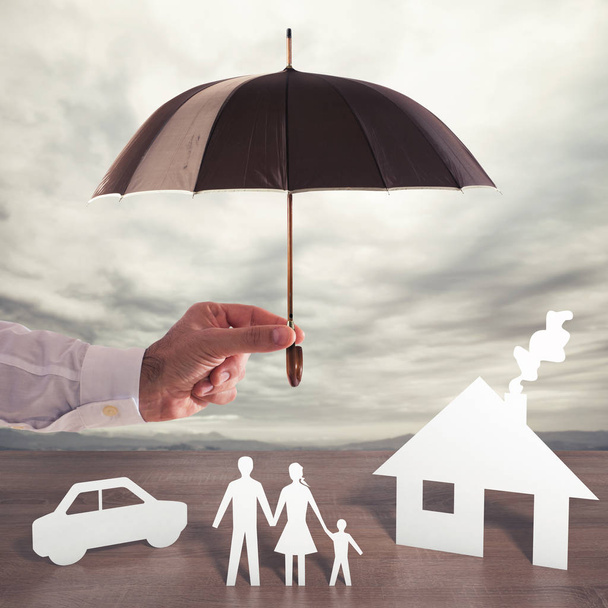 Χαρτί οικογένεια που καλύπτονται από μια ομπρέλα. - Φωτογραφία, εικόνα