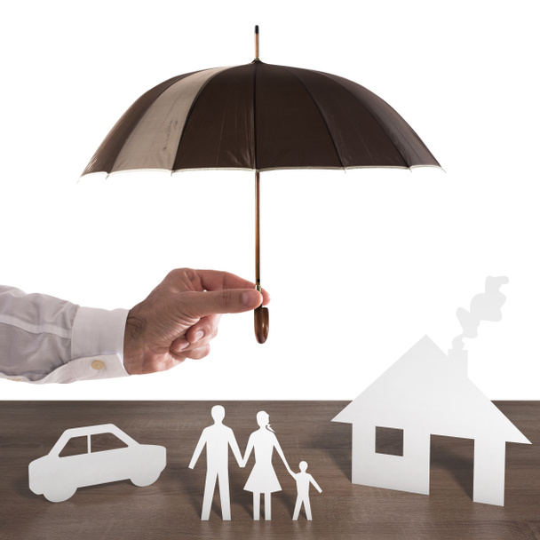 Бумажная семья, покрытая зонтиком
.  - Фото, изображение