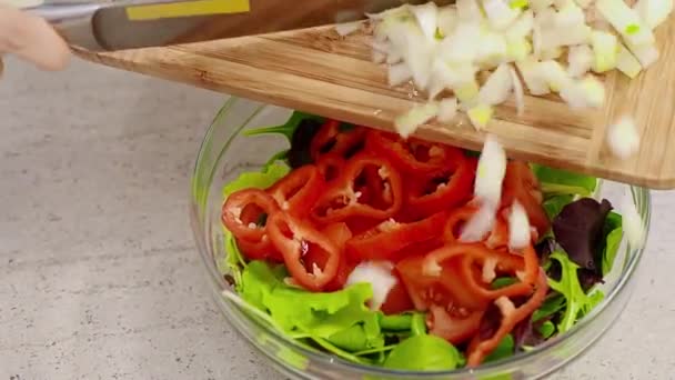 Pouring white onion on fresh vegetable salad - Video