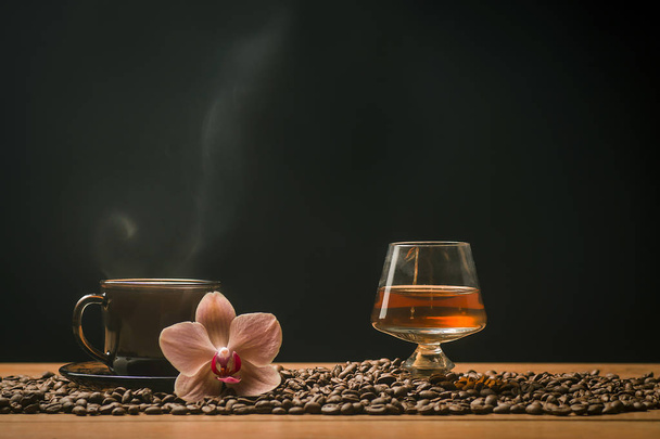 Ζεστός καφές, ορχιδέα και ένα ποτήρι του κονιάκ  - Φωτογραφία, εικόνα