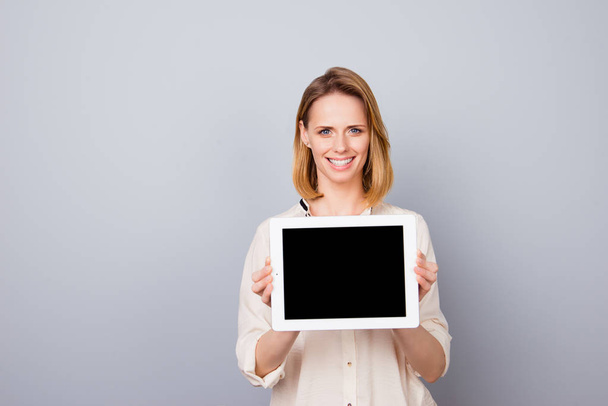 Smiling attractive blond woman is holding laptop. She is wearing - Foto, Bild