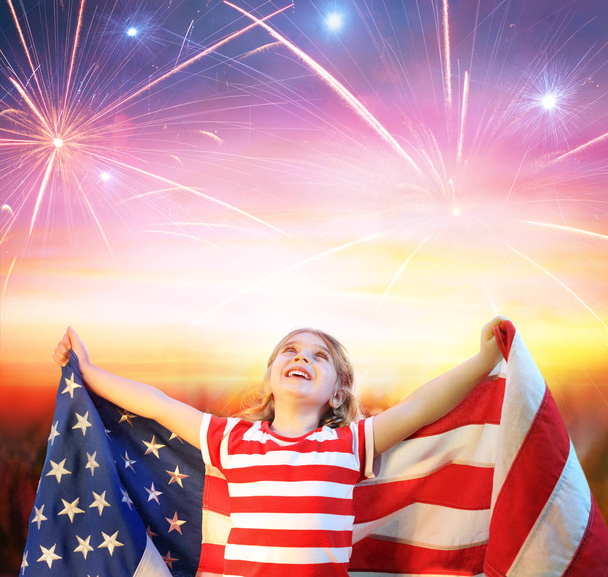 Bambina con bandiera Usa che festeggia sotto i fuochi d'artificio
 - Foto, immagini
