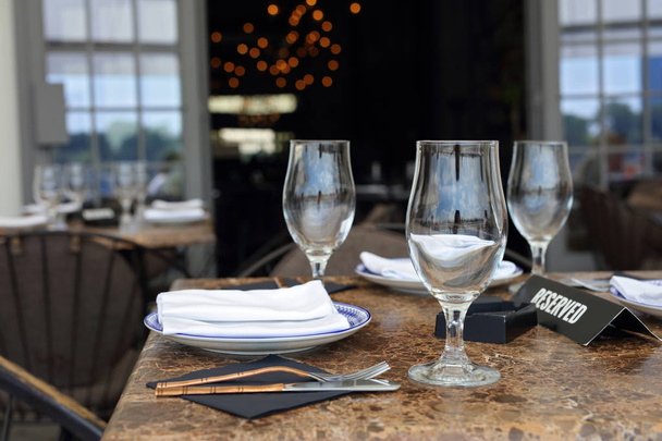 Sinal reservado na mesa do restaurante com pratos e copos vazios
 - Foto, Imagem
