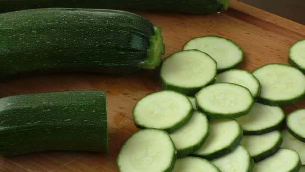 Fresh sliced zucchini on cutting board, on wooden background - Footage, Video