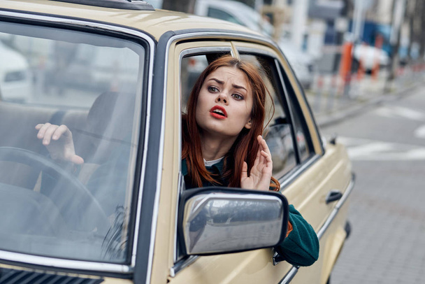 Woman driving a retro car, young woman driving a car - Фото, изображение