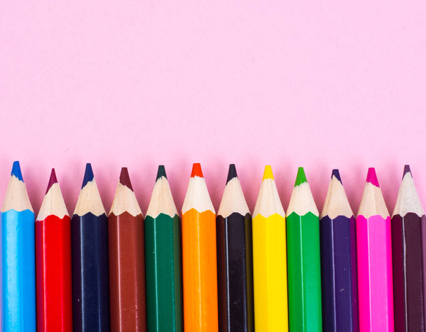 Разноцветные карандаши на фоне розовой бумаги
 - Фото, изображение