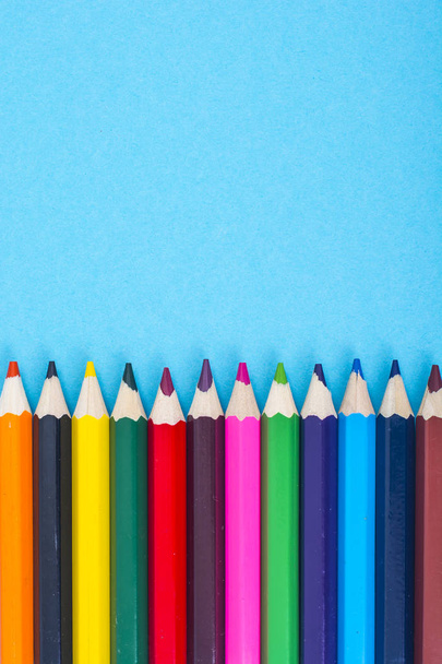 Stationery: colored pencils on blue background. - Photo, Image