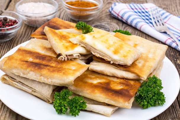 Witte plaat met enveloppen van dunne Armeense lavash gebakken brood - Foto, afbeelding