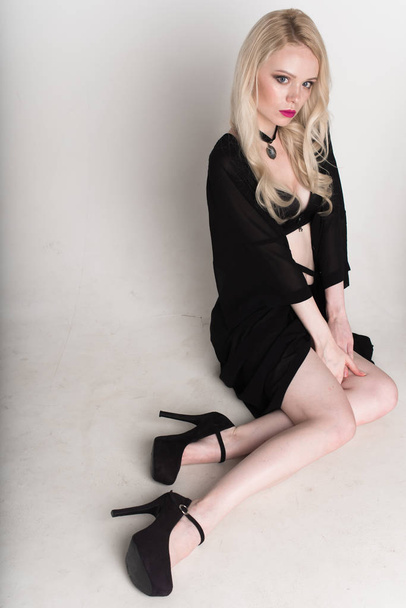 jeune femme blonde souriante sexy en lingerie noire posant sur fond blanc
. - Photo, image