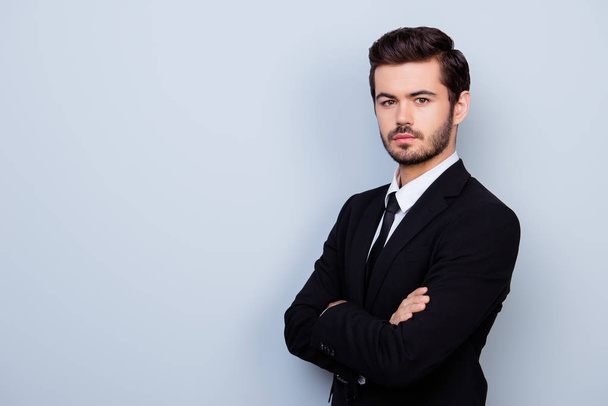 Young confident man in black suit with crossed hands standing ha - Fotoğraf, Görsel