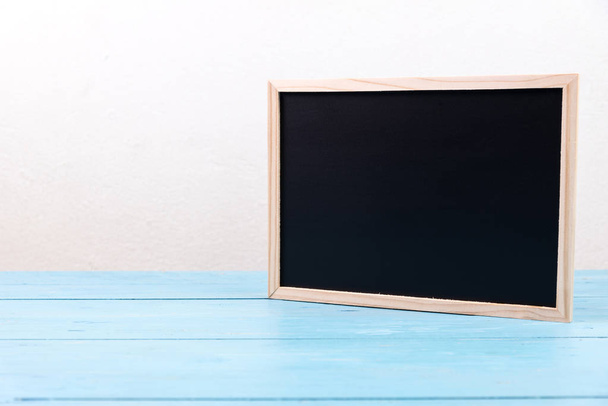 small wooden black board on blue table - Zdjęcie, obraz