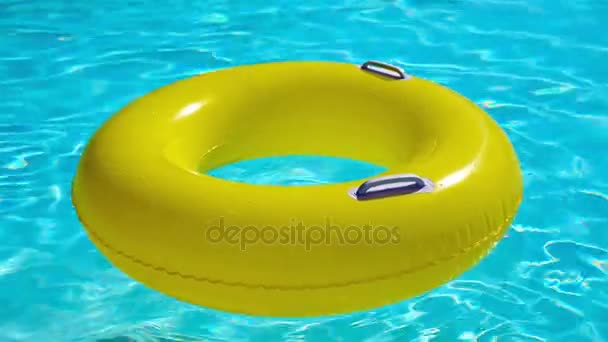 Swimming pool with a brightly yellow inflatable ring - Footage, Video
