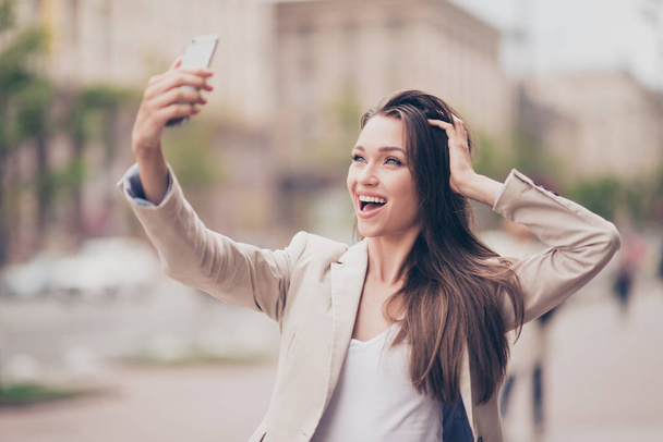 Selfie mania! Excited young girl is making selfie on a camera. S - Foto, afbeelding