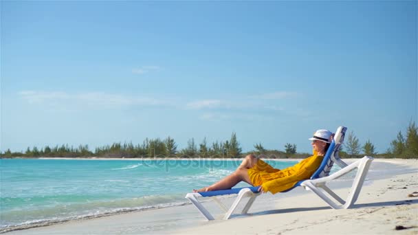 Молодая женщина отдыхает на шезлонге на тропическом пляже
 - Кадры, видео