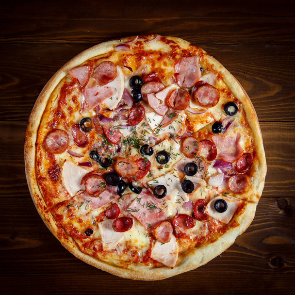 Νόστιμη σπιτική πίτσα με μοτσαρέλα, ζαμπόν, ελιές και μάραθο - Φωτογραφία, εικόνα