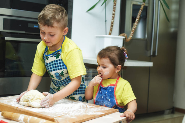çocuklara anne yemek yemek yardım. Ev yapımı yiyecek ve küçük yardımcıları - Fotoğraf, Görsel