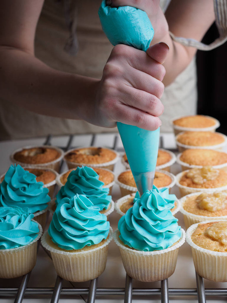 Baking cupcakes. Making cream head by pastry bag - Фото, зображення