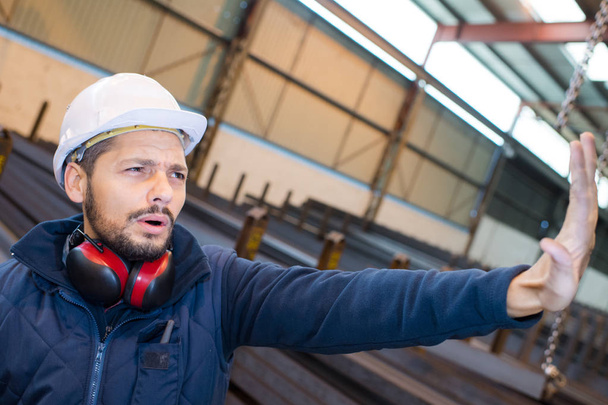 работник завода делает жест, чтобы остановить с ладонью руки
 - Фото, изображение