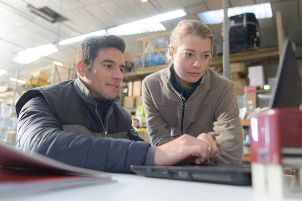 warehouseman and female supervisor with laptop - Фото, зображення