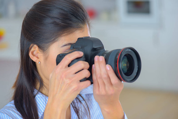 Fotografo donna ragazza è in possesso di fotocamera dslr scattare fotografie
 - Foto, immagini