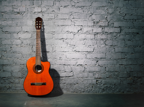 akustická kytara, opíraje se o zeď výstřední - Fotografie, Obrázek