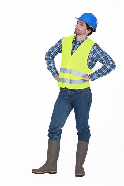 Craftsman wearing hard hat standing with arms akimbo - Photo, image