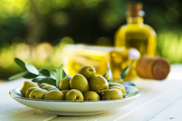 Plate of olives and bottles of olive oil on the table - Fotografie, Obrázek