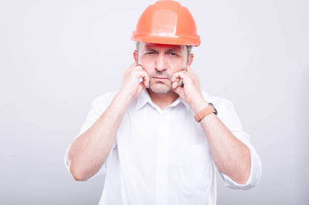 Портрет подрядчика в каске, закрывающем уши
 - Фото, изображение