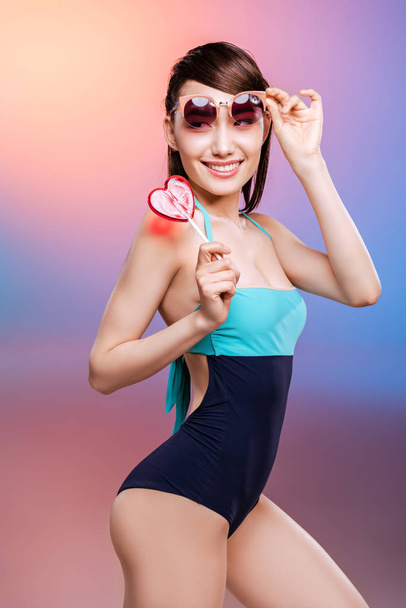 Girl in swimsuit eating candy  - Fotografie, Obrázek