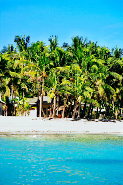 Beautiful white coral sand beach with palms and cottages on the island in Asia - Photo, Image